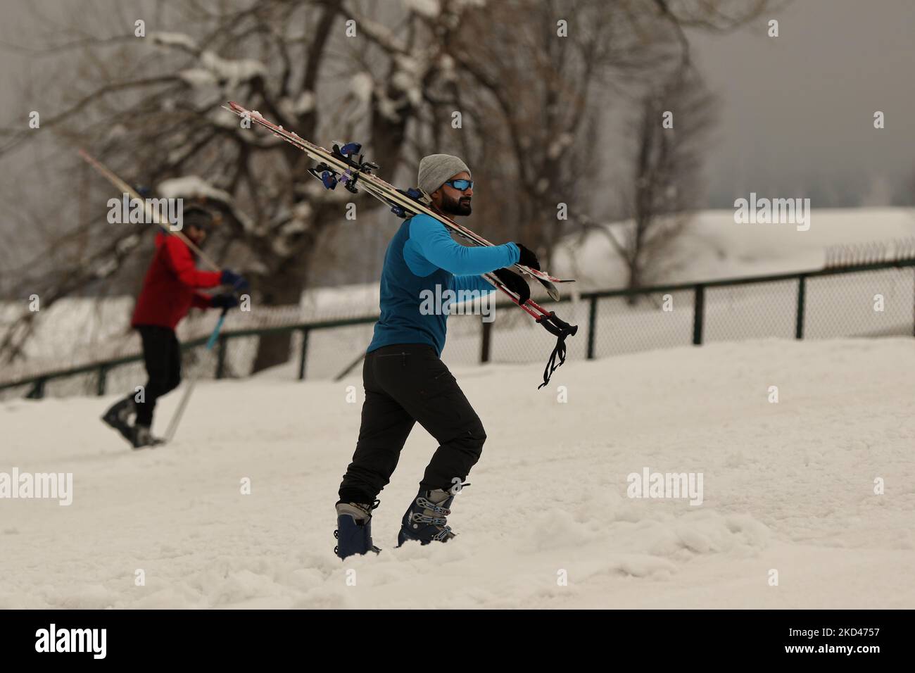 Gli sciatori camminano con gli sci sulle loro spalle alla famosa destinazione turistica Gulmarg, Baramulla, Jammu e Kashmir, il 04 marzo 2022. (Foto di Nasir Kachroo/NurPhoto) Foto Stock