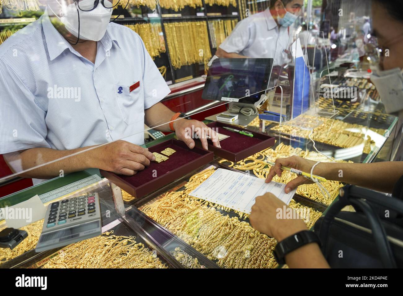 Un venditore di oro controlla il peso delle barre d'oro prima di commerciare in un negozio d'oro a Chinatown, Bangkok, Thailandia, 10 marzo 2022. La gente si è affollata per vendere i loro ornamenti dopo che il prezzo dell'oro è aumentato bruscamente sopra 30.800 baht thailandese (930,16 dollaro US) per il baht-peso per le barre dell'oro il 10 marzo 2022. Secondo la Thai Gold Traders Association, è il più alto prezzo d'oro dal marzo 2021. (Foto di Anusak Laowilas/NurPhoto) Foto Stock