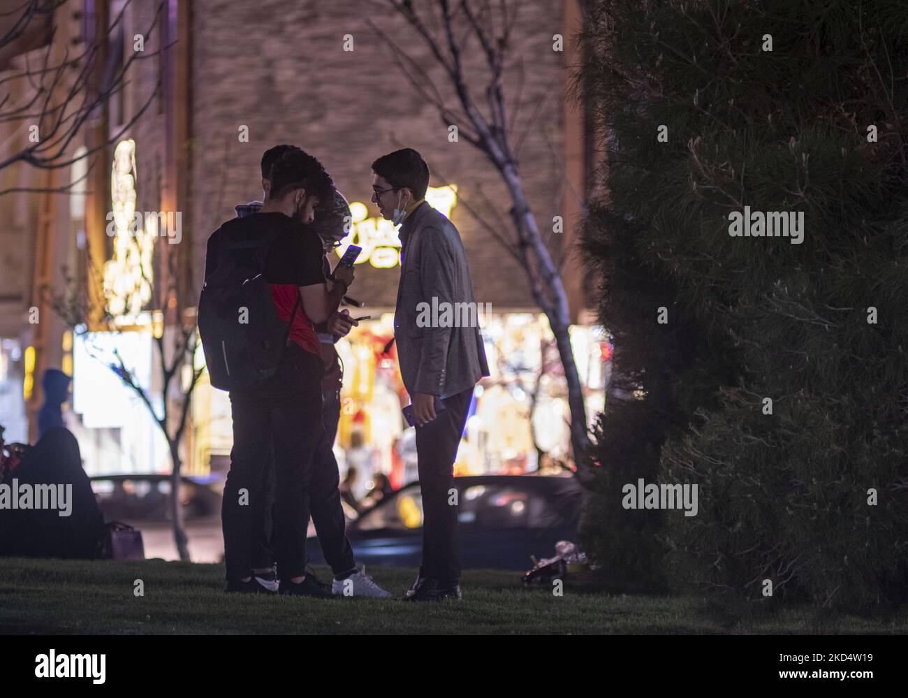 I giovani iraniani stanno insieme mentre controllano le loro pagine sulle piattaforme dei Social Media sui loro smartphone in una piazza nella città Santa di Qom 145km (90 miglia) a sud di Teheran il 10 marzo 2022. (Foto di Morteza Nikoubazl/NurPhoto) Foto Stock