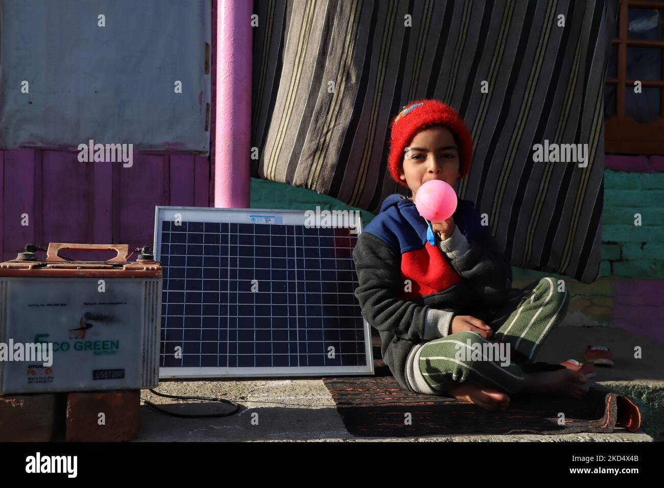 Misba, riempie l'aria in un pallone come lei si siede vicino a un pannello solare Home in una zona lontana flung di Kupwara Jammu e Kashmir India il 12 marzo 2022 (Foto di Nasir Kachroo/NurPhoto) Foto Stock
