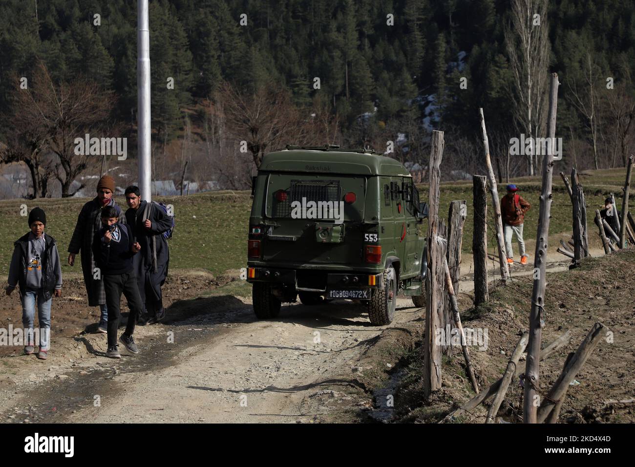 I ragazzi di Kashmiri camminano mentre un veicolo dell'esercito indiano si muove attraverso un'area lontana in Kupwara Jammu e Kashmir India il 12 marzo 2022 (Foto di Nasir Kachroo/NurPhoto) Foto Stock