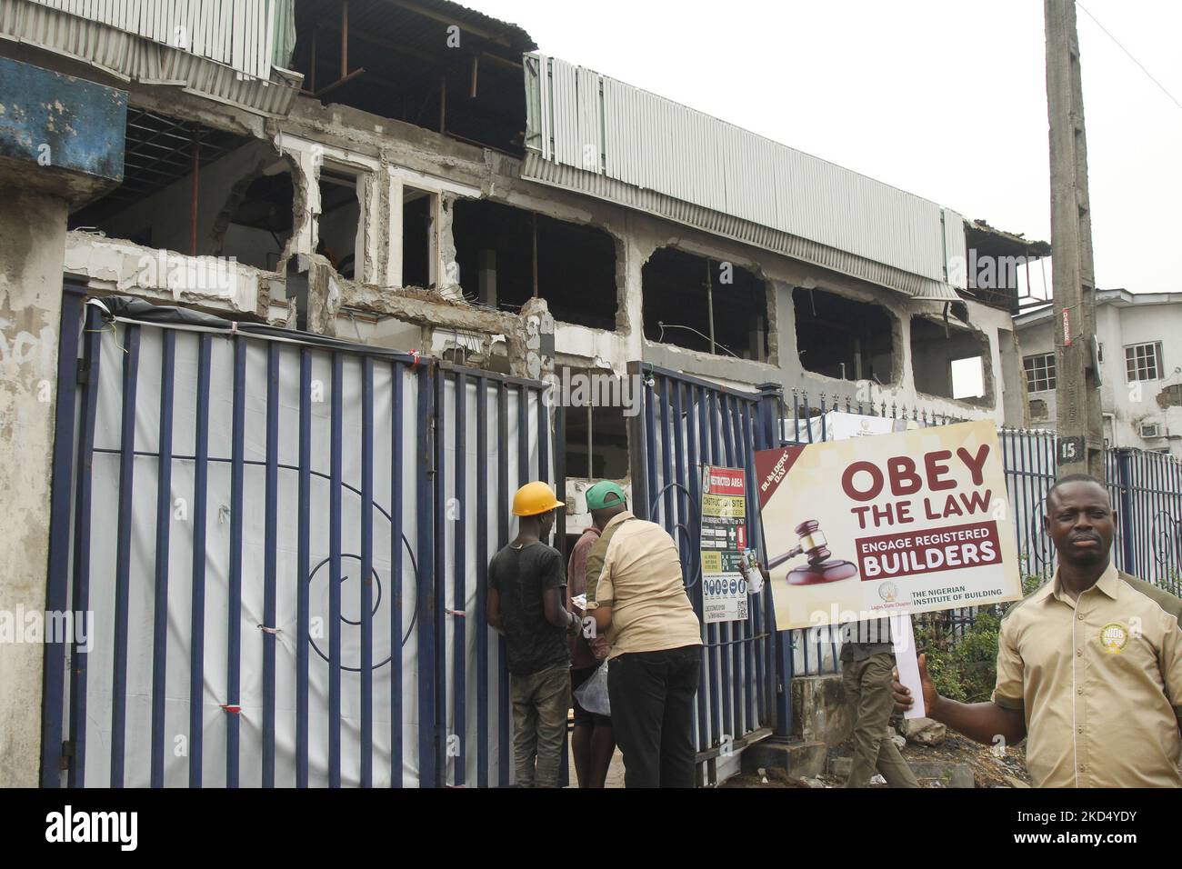 Un lavoratore edile riceve un volantino a Ikeja, mentre l'Istituto nigeriano dell'edilizia, in collaborazione con la Building Collapse Prevention Guild, tiene una passeggiata contro il collasso dell'edificio, con il tema "costruire con integrità", nell'ambito delle attività che segnano la Giornata dei costruttori del 2022 a Ikeja, Lagos, Nigeria, sabato 12 marzo; 2022. (Foto di Adekunle Ajayi/NurPhoto) Foto Stock