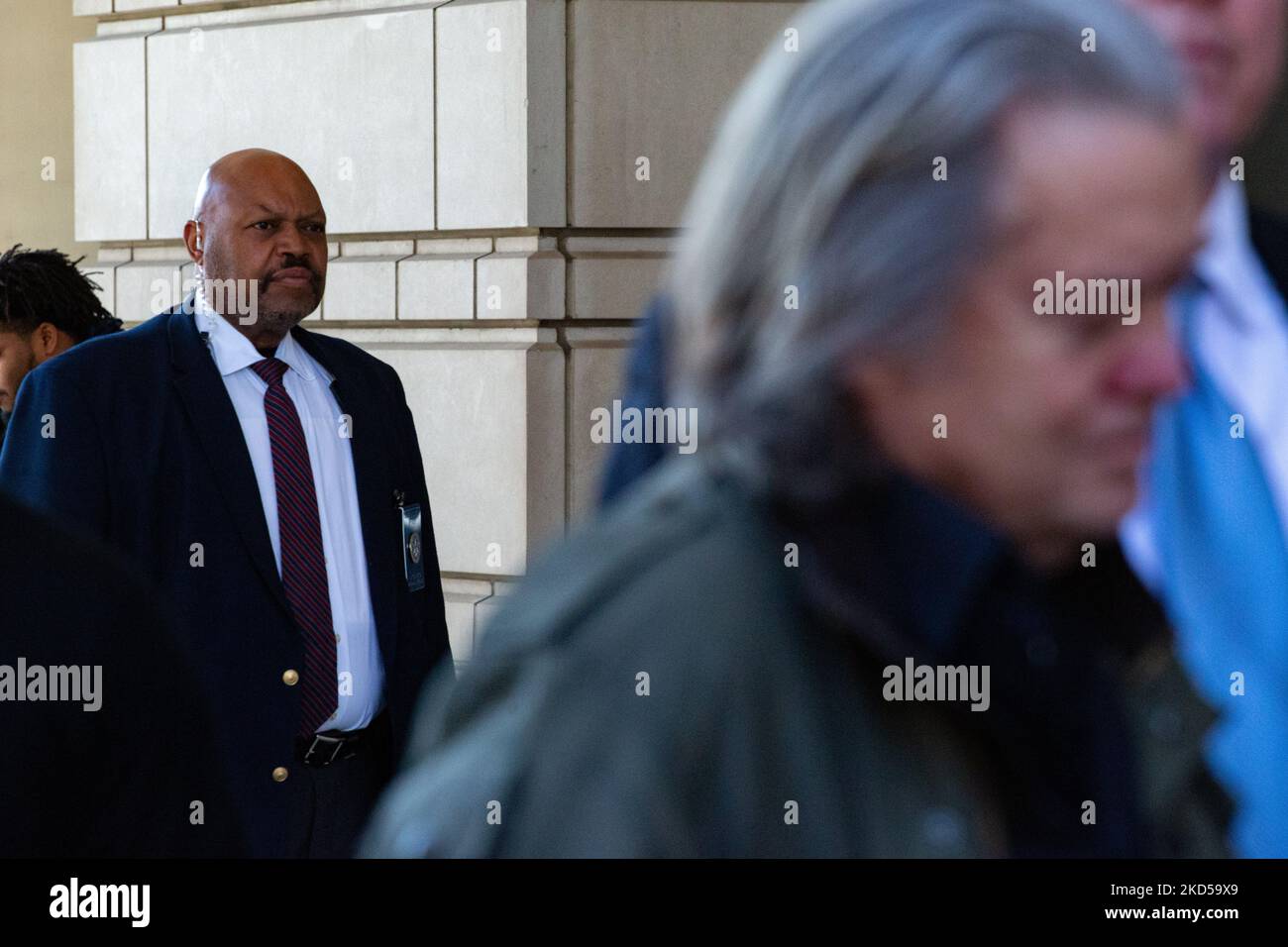 Una guardia di sicurezza si trova dietro l'ex stratega Trump Steve Bannon mentre parla ai media al di fuori del E. Barrett Prettyman United States Federal Courthouse a Washington, D.C. il 16 marzo 2022 (Photo by Bryan Olin Dozier/NurPhoto) Foto Stock