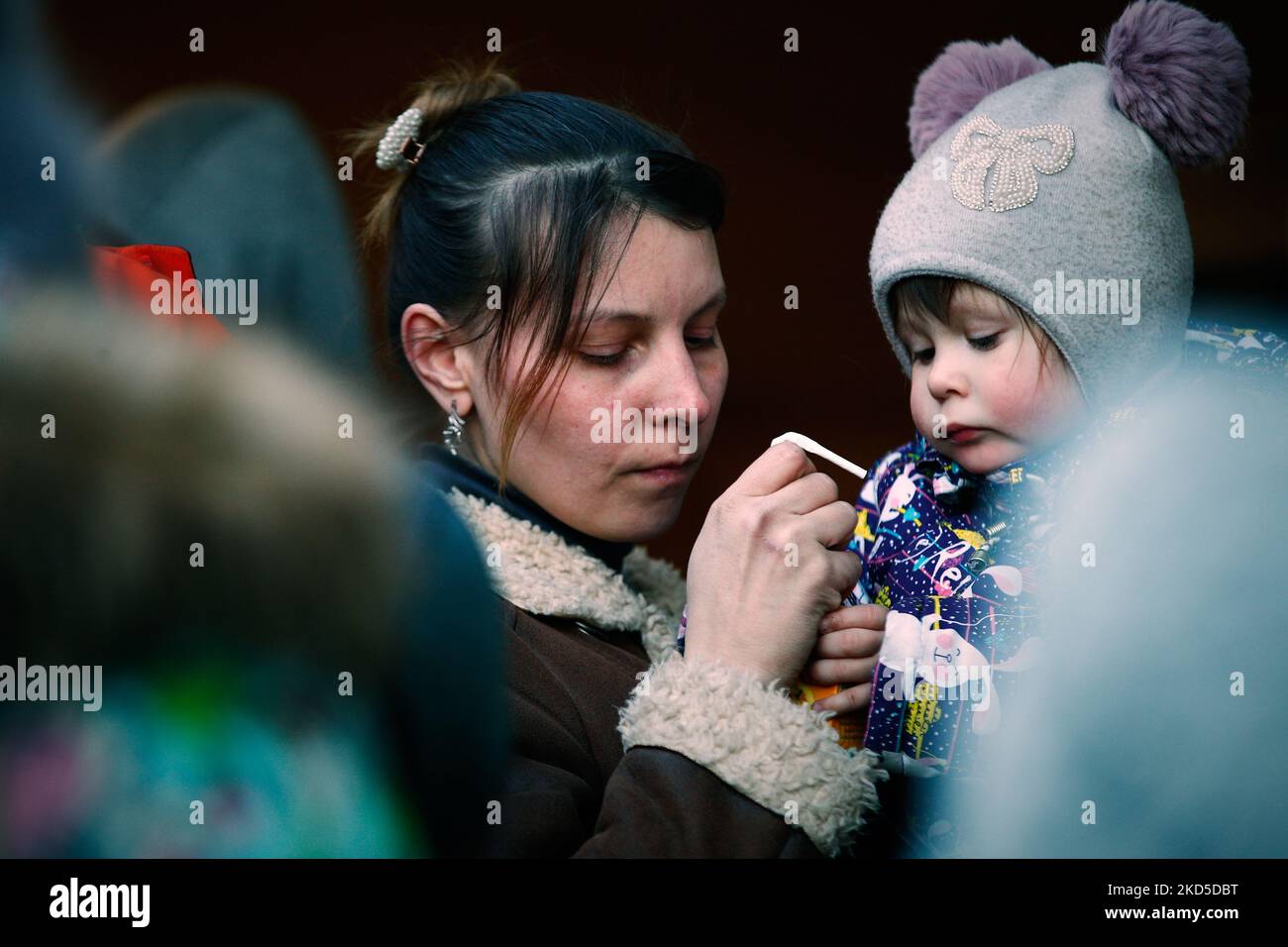 Una donna si vede consegnare un drink ad un bambino vicino alla stazione centrale di Varsavia, Polonia il 18 marzo 2022. La Polonia ha accolto oltre 1,5 milioni di rifugiati in fuga dall'invasione russa del loro paese dal 24 febbraio 2022. Solo a Varsavia la popolazione è cresciuta di circa il 20 per cento a causa dell'afflusso di rifugiati. La pressione sulle risorse ha spinto il sindaco di Varsavia, Rafal Trzaskowski, a chiedere il sostegno dell'Unione europea e delle Nazioni Unite. (Foto di Str/NurPhoto) Foto Stock