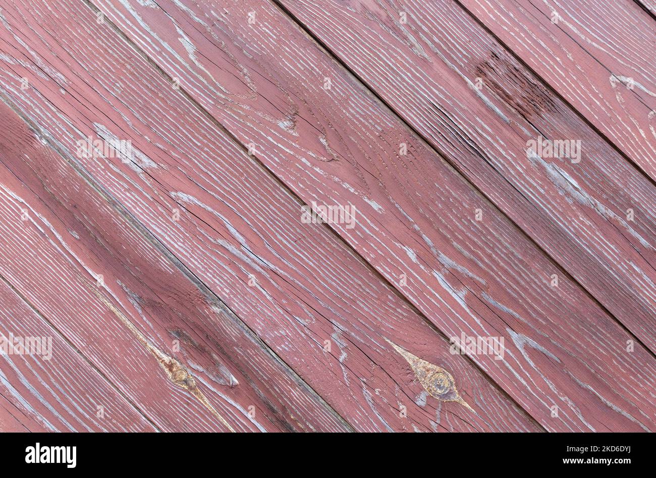 Recinzione fatta di vecchie tavole di legno ruvide con peeling di vernice marrone scuro. Disposizione diagonale Foto Stock