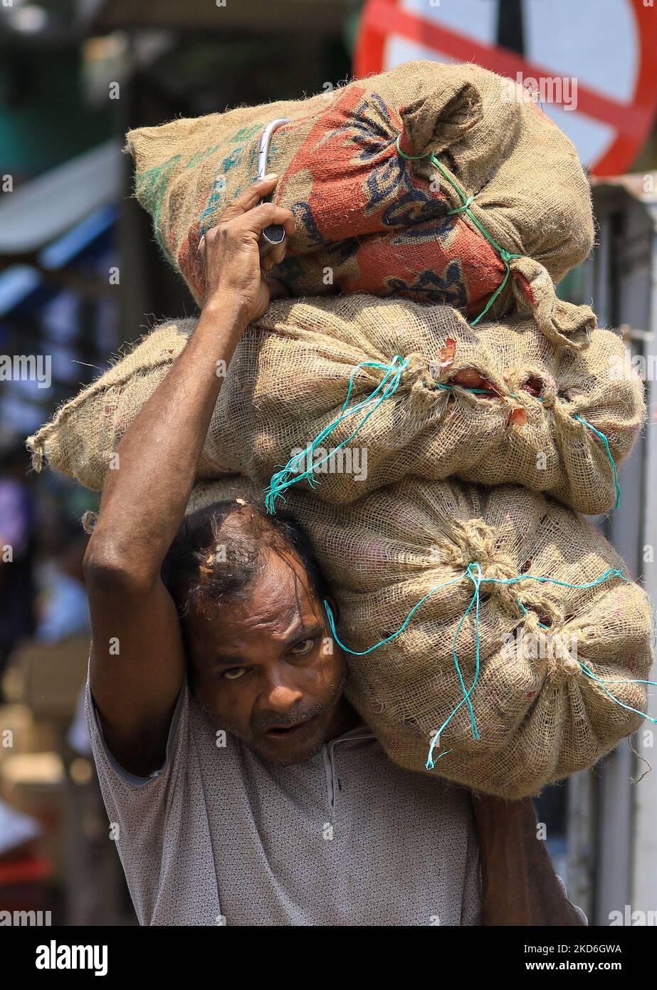 Un lavoratore salariale quotidiano dello Sri Lanka trasporta sacchi di verdure sulle sue spalle al principale mercato locale di Pettah, Colombo, Sri Lanka. 1 aprile 2022. (Foto di Tharaka Basnayaka/NurPhoto) Foto Stock