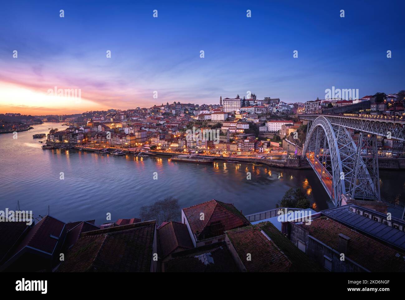 Skyline di Porto illuminato con il fiume Douro e il ponte Dom Luis i al tramonto - Porto, Portogallo Foto Stock