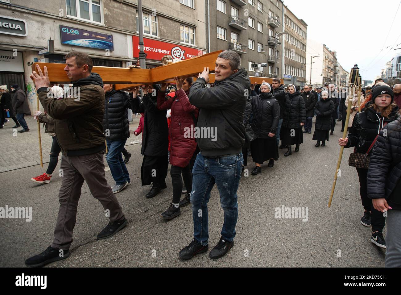 Gli ucraini che abitano in città portando una croce gigante sulle loro spalle per la processione della Via Crucis sono visti il 8 aprile 2022 a Gdynia, Polonia. La Via Crucis, nota anche come Via dei dolori o Via Crucis, si osservano di solito durante la Quaresima, specialmente il venerdì quaresimale e soprattutto il venerdì santo. È una delle devozioni più popolari per i cattolici romani. La devozione consiste nel meditare su 14 eventi che formano le 14 stazioni della croce. Lo scopo di questa devozione è quello di concentrarsi sulla Passione di Gesù Cristo. (Foto di Michal Fludra/NurPhoto) Foto Stock