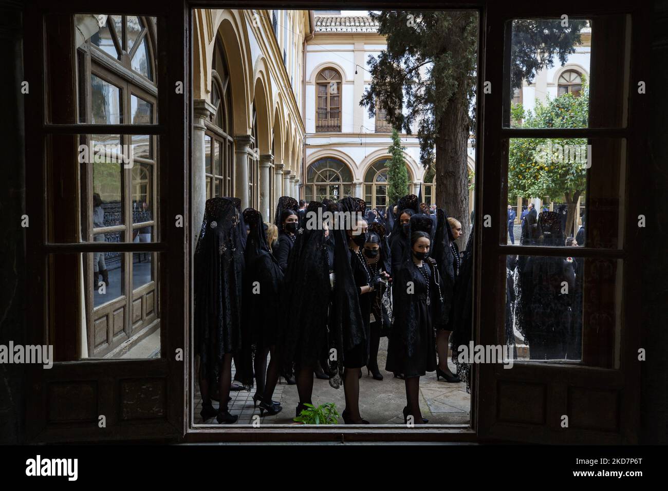 I Penitenti vestiti di nero dalla Confraternita degli Escolapios si preparano ad iniziare la loro processione durante il Venerdì Santo a Granada, Spagna, il 15 aprile 2022. La settimana Santa torna in Spagna con le tradizionali processioni nelle strade dopo due anni di interruzione a causa della pandemia di coronavirus. (Foto di Ãlex CÃ¡mara/NurPhoto) Foto Stock