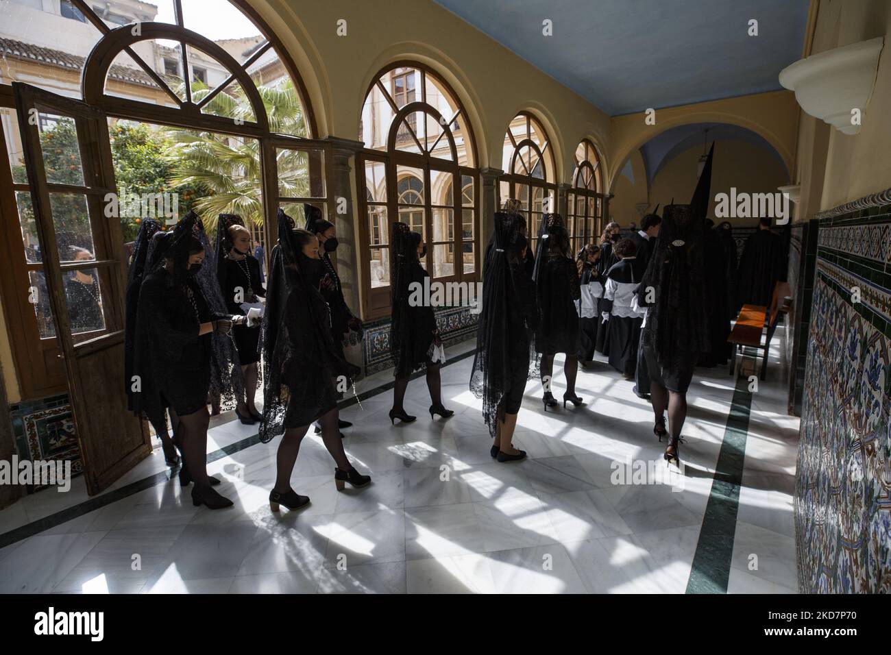 I Penitenti vestiti di nero dalla Confraternita degli Escolapios si preparano ad iniziare la loro processione durante il Venerdì Santo a Granada, Spagna, il 15 aprile 2022. La settimana Santa torna in Spagna con le tradizionali processioni nelle strade dopo due anni di interruzione a causa della pandemia di coronavirus. (Foto di Ãlex CÃ¡mara/NurPhoto) Foto Stock