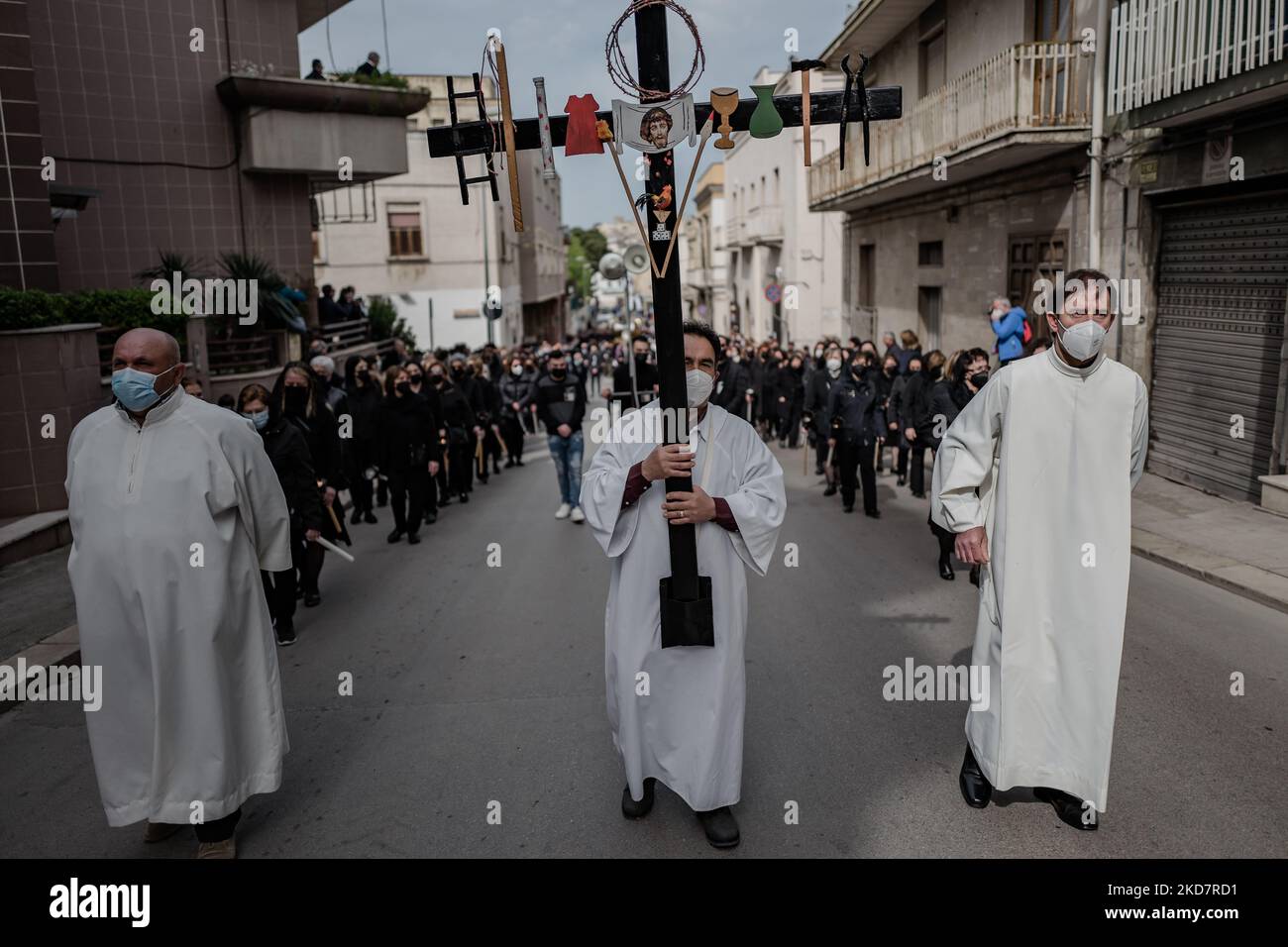 La croce tenuta da alcuni altari il sabato Santo durante la processione della Desolata a Canosa di Puglia il 16 aprile 2022. La Processione della desolazione è uno dei più importanti e significativi riti religiosi della settimana Santa a Canosa di Puglia, che si svolge il sabato Santo. L'elemento più suggestivo che da sempre contraddistingue questa Processione è rappresentato dal coro composto da donne vestite di nero, che da oltre 50 anni sono state ininterrottamente dirette dal Maestro Mimmo Masotina, ora dal figlio Ezio, Che cantano l'Inno del desolato, esprimendo all'unisono il loro dolore A. Foto Stock
