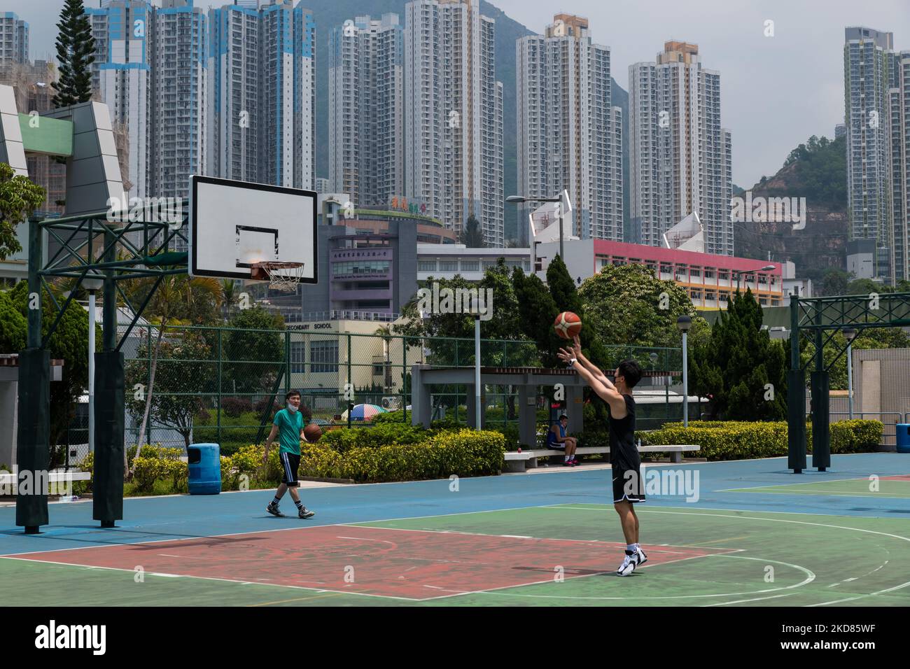 Un giovane gioca a basket su un terreno recentemente riaperto a Kowloon Bay. (Foto di Marc Fernandes/NurPhoto) Foto Stock