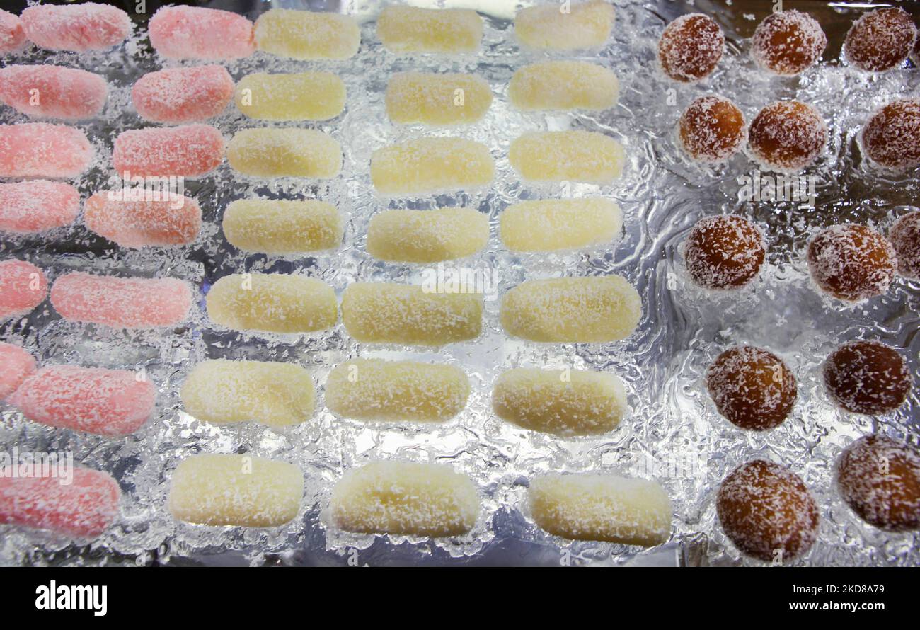 Coloratissimi chum rosa e giallo accanto ai gamuns gulab visti disposti su un tavolo fatto interamente di ghiaccio in occasione di un matrimonio indiano a Toronto Ontario Canada. Sia il chum chum che il gulab jamun sono dolci indiani popolari. (Foto di Creative Touch Imaging Ltd./NurPhoto) Foto Stock