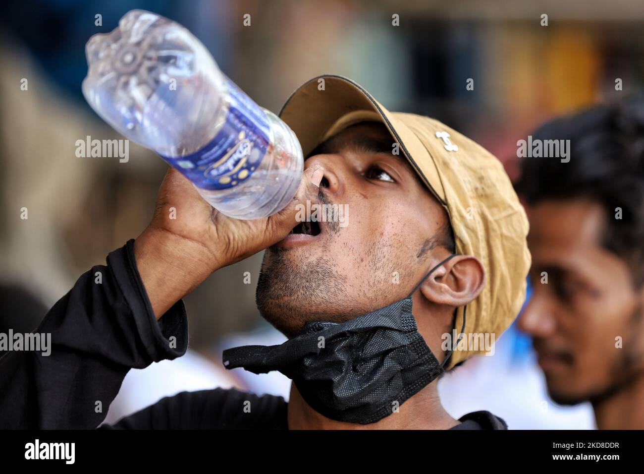Un ragazzo beve acqua da una bottiglia in una calda giornata estiva a Old Delhi, India, il 25 aprile 2022. (Foto di Nasir Kachroo/NurPhoto) Foto Stock