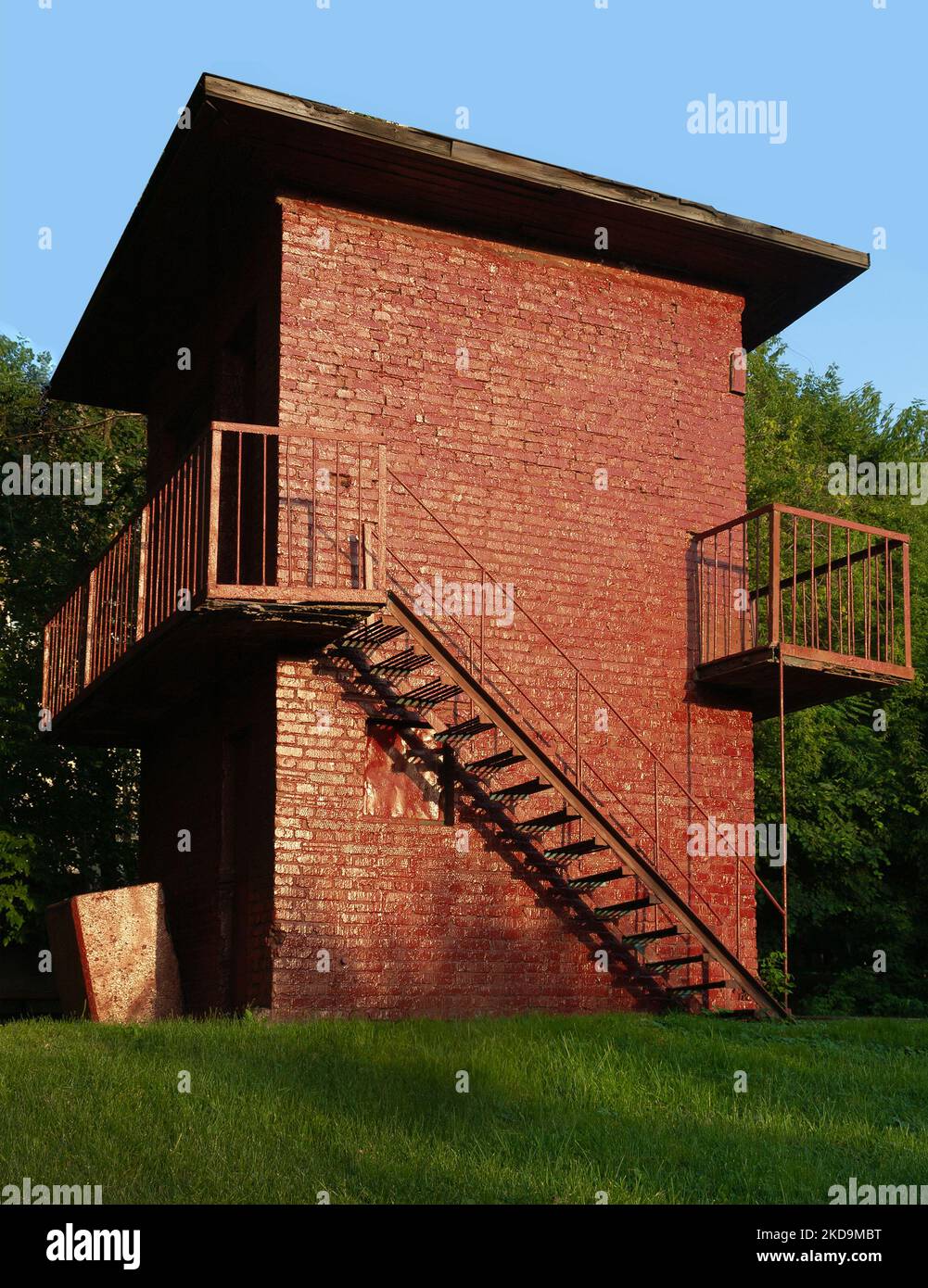 vecchio annata piccolo edificio industriale senza finestre dipinto capanna in mattoni con scala esterna in metallo, un impianto di pompaggio dell'acqua Foto Stock