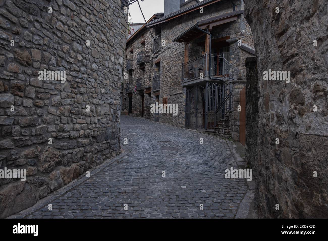 Una strada stretta tra vecchi edifici medievali in pietra nel comune di Torla-Ordesa a Huesca, Spagna Foto Stock