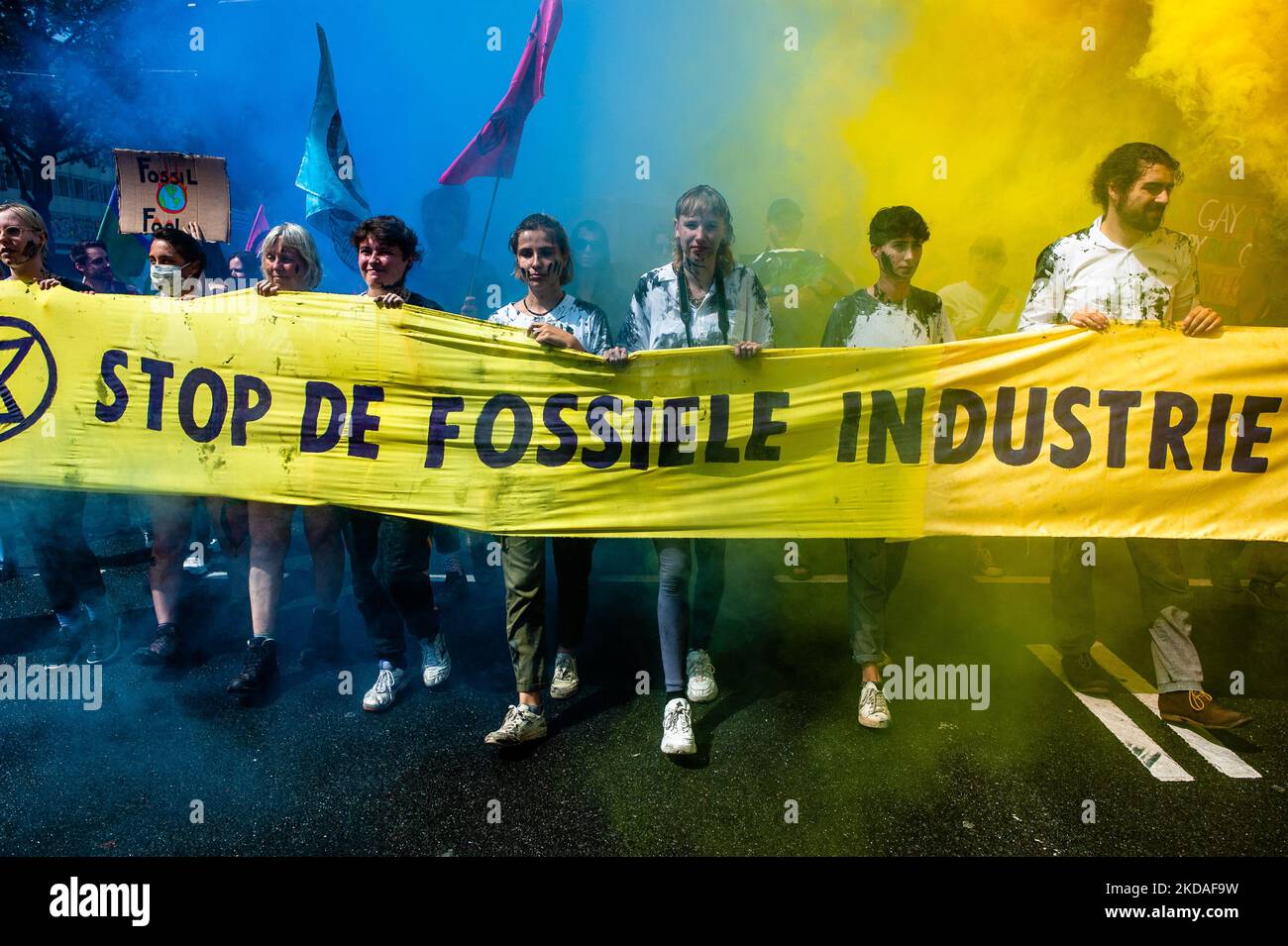 GLI attivisti DELLA XR stanno tenendo una grande bandiera contro i combustibili fossili circondati da fumo blu e giallo, durante una dimostrazione organizzata dalla XR contro l'industria fossile a Rotterdam, il 19th maggio 2022. (Foto di Romy Arroyo Fernandez/NurPhoto) Foto Stock