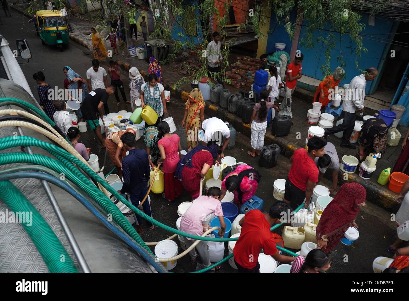 I residenti riempiono i loro contenitori di plastica con acqua potabile da una cisterna municipale, in una calda giornata estiva a Nuova Delhi, India il 30 maggio 2022. Il clima estremo ha aggravato la crisi di potere del paese e la recente produzione di colture. L'India ha sofferto sotto il caldo record negli ultimi due mesi, il più caldo degli ultimi 122 anni. (Foto di Mayank Makhija/NurPhoto) Foto Stock