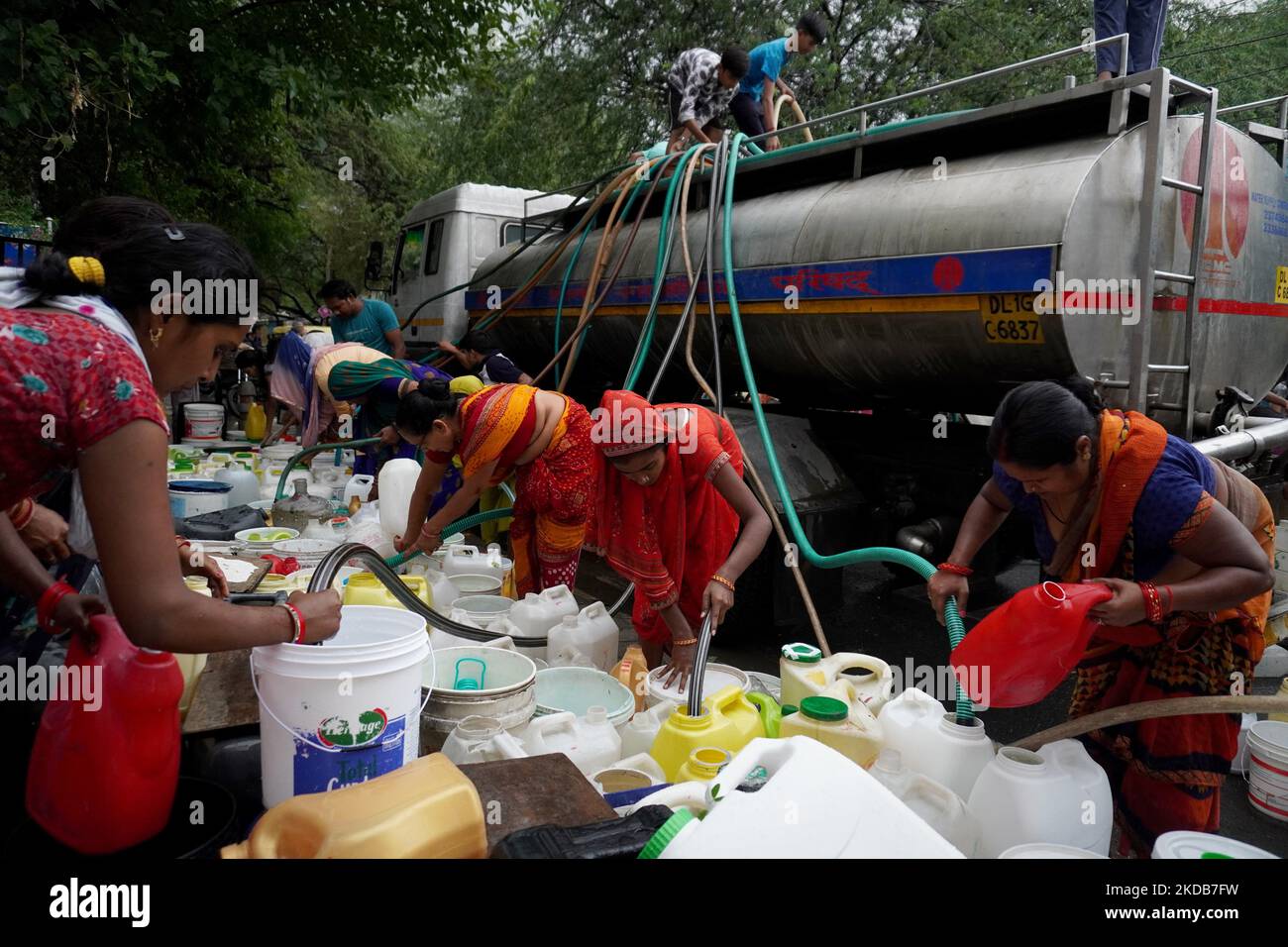 I residenti riempiono i loro contenitori di plastica con acqua potabile da una cisterna municipale, in una calda giornata estiva a Nuova Delhi, India il 30 maggio 2022. Il clima estremo ha aggravato la crisi di potere del paese e la recente produzione di colture. L'India ha sofferto sotto il caldo record negli ultimi due mesi, il più caldo degli ultimi 122 anni. (Foto di Mayank Makhija/NurPhoto) Foto Stock