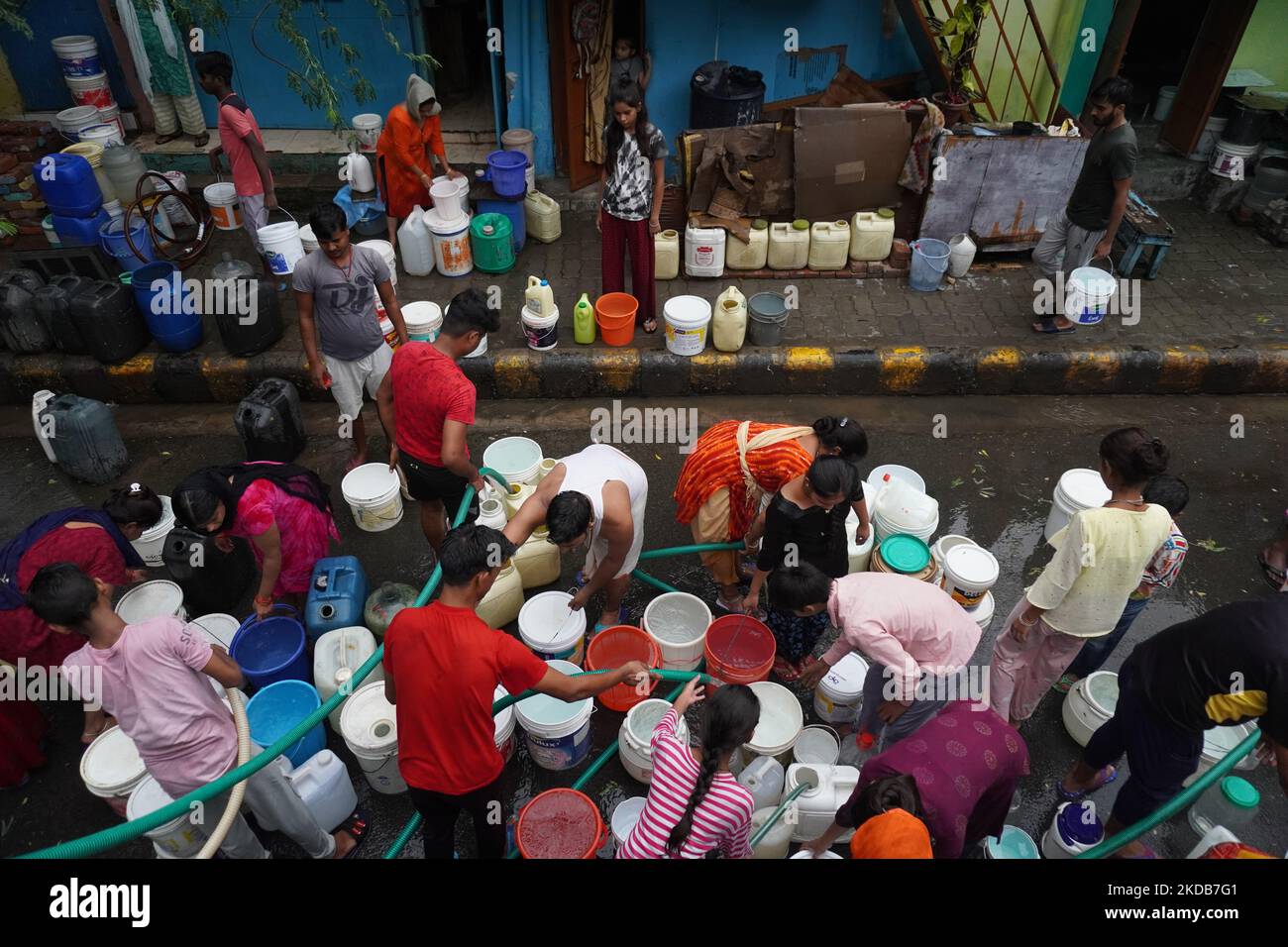 I residenti riempiono i loro contenitori di plastica con acqua potabile da una cisterna municipale, in una calda giornata estiva a Nuova Delhi, India il 30 maggio 2022. Il clima estremo ha aggravato la crisi di potere del paese e la recente produzione di colture. L'India ha sofferto sotto il caldo record negli ultimi due mesi, il più caldo degli ultimi 122 anni. (Foto di Mayank Makhija/NurPhoto) Foto Stock