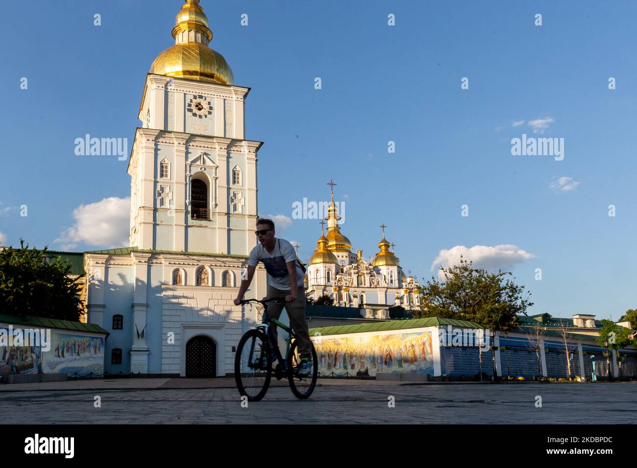 Un uomo guida una bicicletta in Piazza Michailovskyi di fronte al Monastero di San Michail nella città vecchia di Kyiv, Ucraina il 8 giugno 2022. Mentre la Federazione Russa ha invaso l'Ucraina 3 mesi e mezzo fa, continuano feroci combattimenti nell'est del paese. La capitale, Kyiv, rimane in relativa sicurezza, anche se i ricordi della guerra come le borse di sabbia protettive, i blocchi stradali, i simboli nazionali e anti-guerra sono presenti in tutta la città. (Foto di Dominika Zarzycka/NurPhoto) Foto Stock