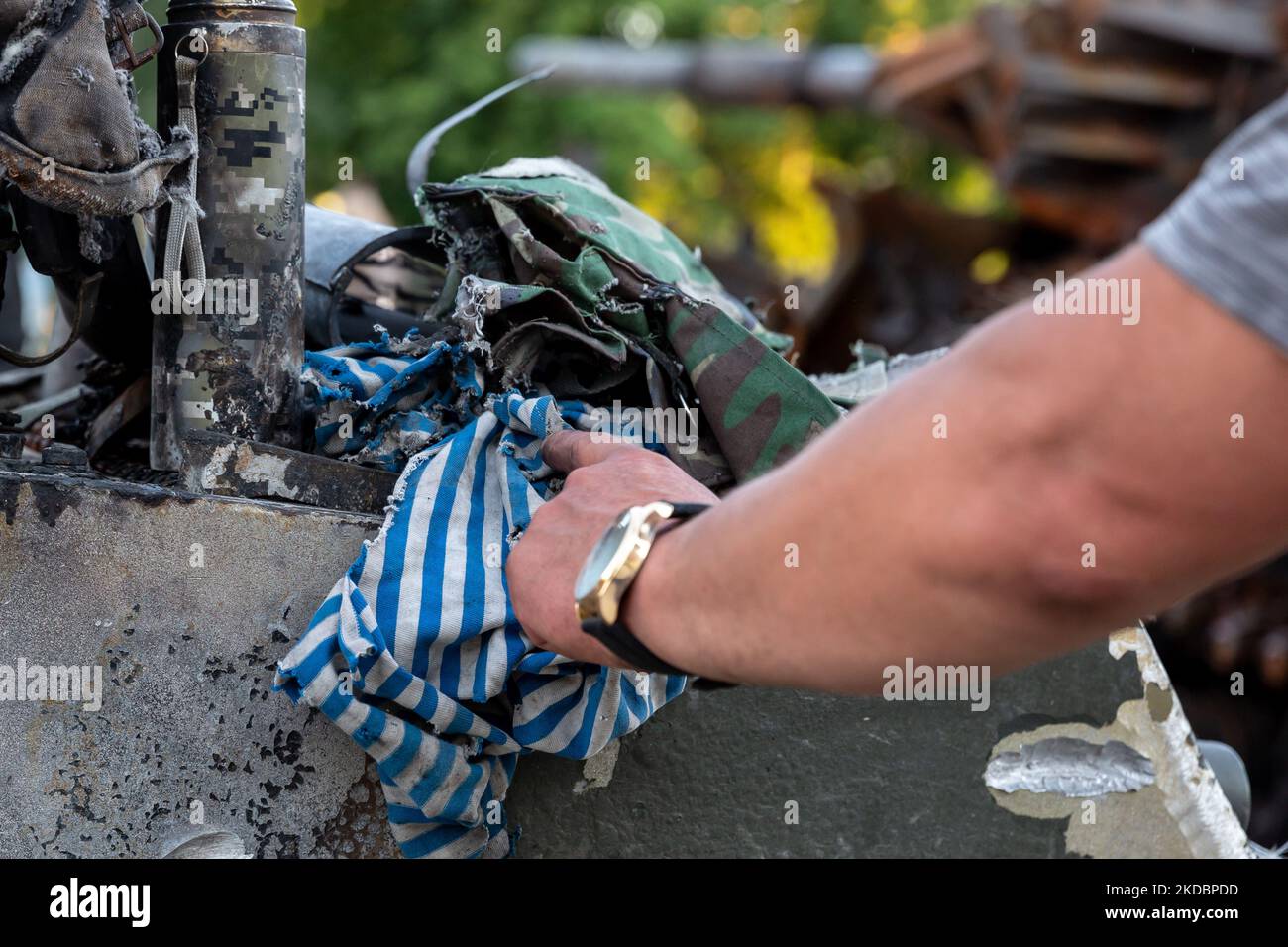 Un uomo tocca una t-shirt strappata mentre frequenta una mostra di veicoli da guerra russi distrutti esposti in Piazza Michailovskyi di fronte al Monastero di San Michail e al Ministero degli Affari Esteri nella Città Vecchia di Kyiv, Ucraina il 8 giugno 2022. Mentre la Federazione Russa ha invaso l'Ucraina 3 mesi e mezzo fa, continuano feroci combattimenti nell'est del paese. La capitale, Kyiv, rimane in relativa sicurezza, anche se i ricordi della guerra come le borse di sabbia protettive, i blocchi stradali, i simboli nazionali e anti-guerra sono presenti in tutta la città. (Foto di Dominika Zarzycka/NurPhoto) Foto Stock