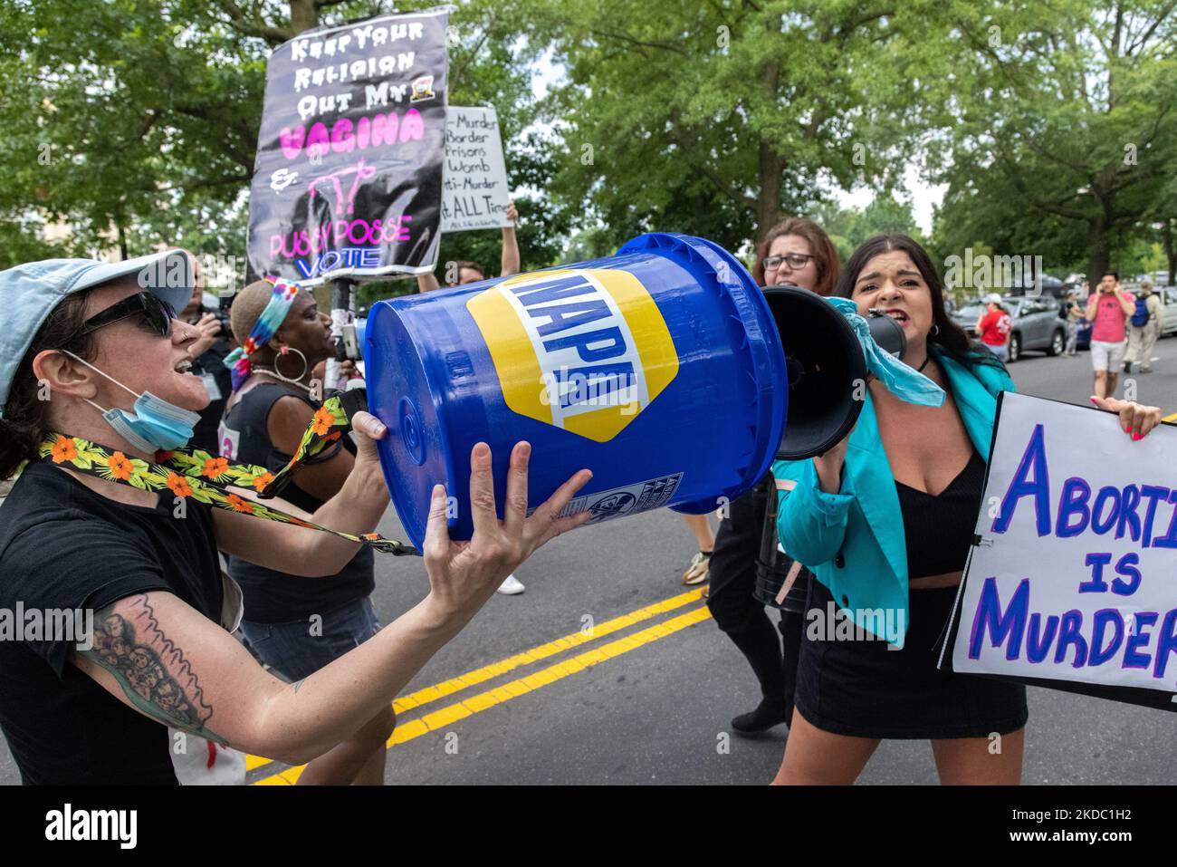 Un dimostratore di diritti di aborto blocca un megafono contro-dimostranti con un secchio durante una marcia alla Corte Suprema a Washington, D.C. il 13 giugno 2022. (Foto di Bryan Olin Dozier/NurPhoto) Foto Stock