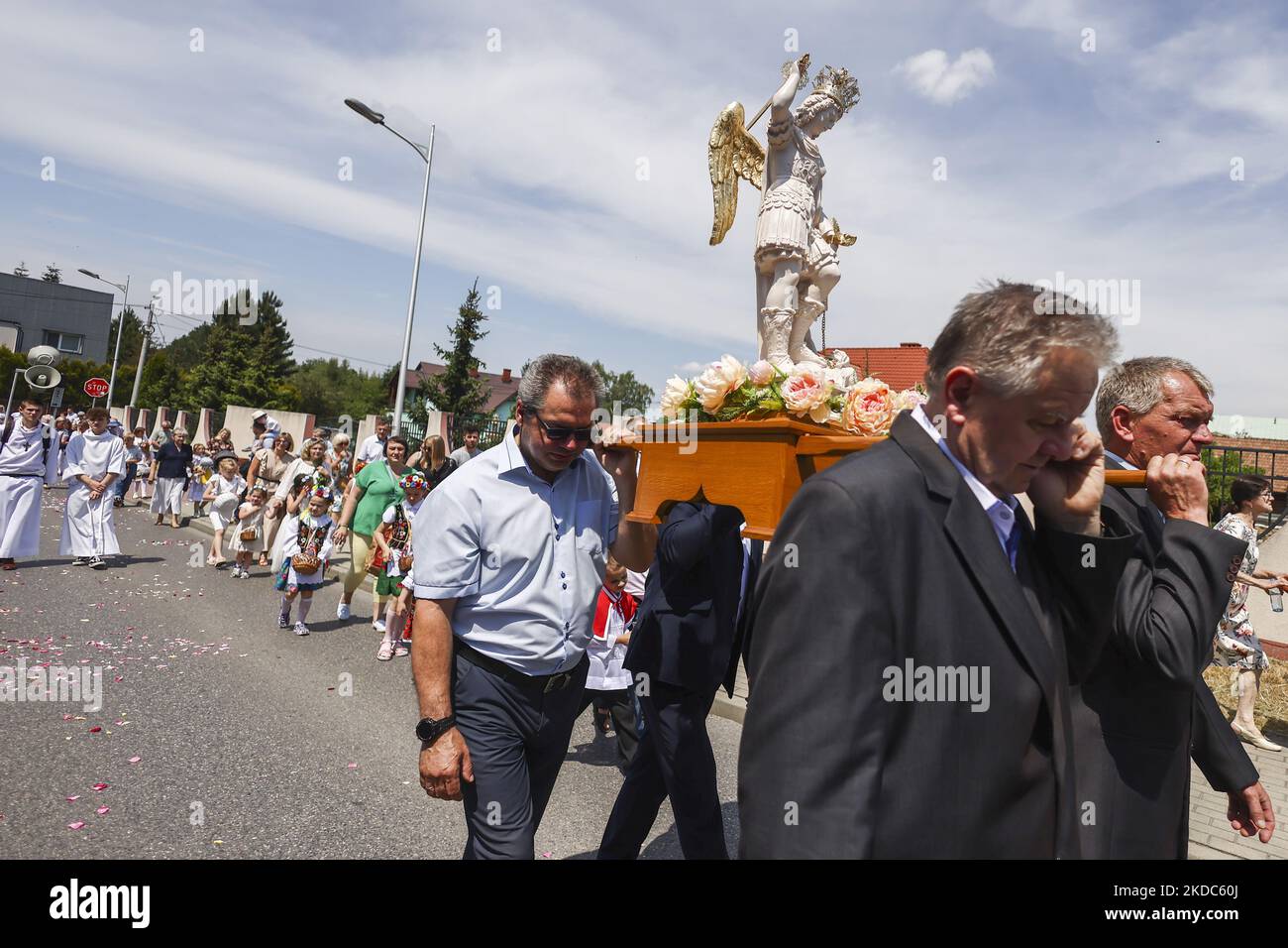 I fedeli partecipano alla processione del Corpus Christi ad Andrychow, Polonia, il 16 giugno 2022. La processione inizia con un sacerdote che porta un mostrania sotto un baldacchino. I fedeli lo seguono cantando inni religiosi, mentre le giovani ragazze vestite con abiti bianchi o tradizionali regionali spargono petali di fiori lungo il percorso. Il Corpus Christi è una festa cattolica mobile che commemora la Transostituzione. (Foto di Beata Zawrzel/NurPhoto) Foto Stock