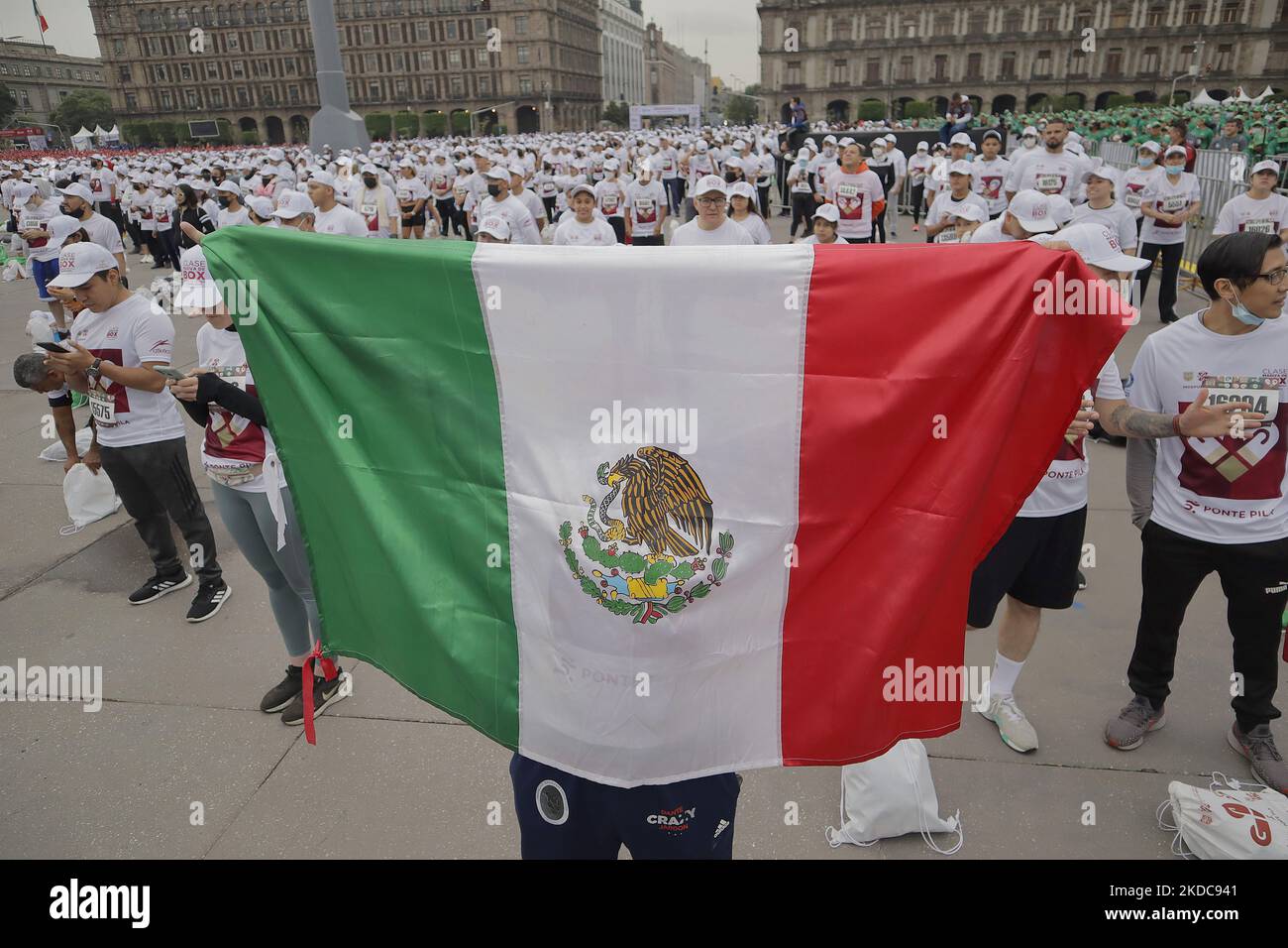 Una persona estende la bandiera messicana durante una massiccia classe di pugilato nella spianata di Zócalo di Città del Messico, che mira a stabilire un nuovo Guinness World Record superando quello stabilito nel 2017 in Russia, con 3.200 persone che prendono la classe allo stesso tempo per 30 minuti. (Foto di Gerardo Vieyra/NurPhoto) Foto Stock