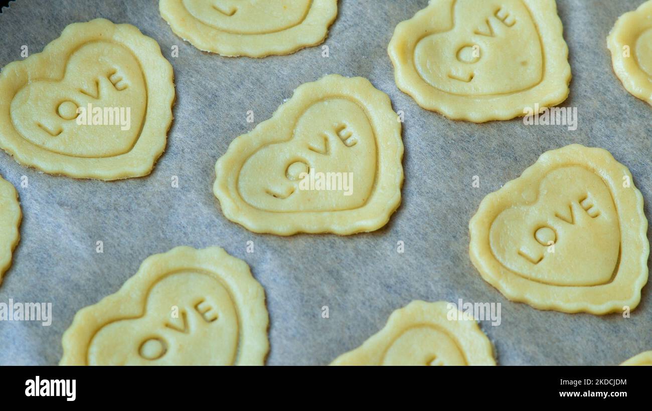 Biscotti fatti in casa con burro a forma di cuore con amore parola. Amore, romanticismo, San Valentino Foto Stock