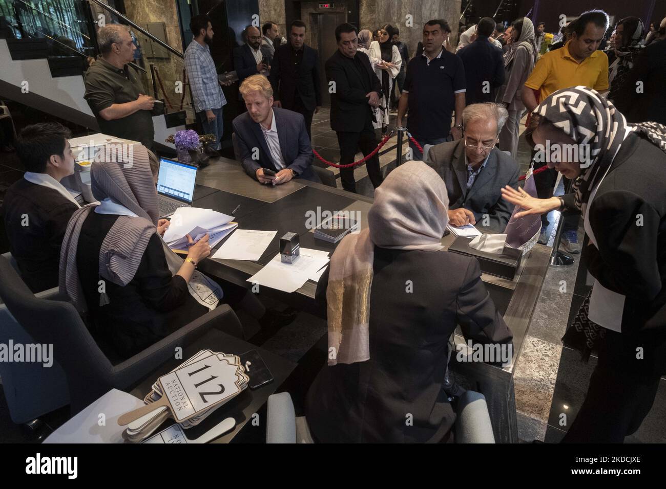 Due uomini si registrano all'asta durante l'asta dell'Arte del mondo Islamico e Iraniano del 7th, tenuta dalla Casa d'aste Melli (Nazionale) in un centro conferenze nel nord di Teheran il 24 giugno 2022. (Foto di Morteza Nikoubazl/NurPhoto) Foto Stock