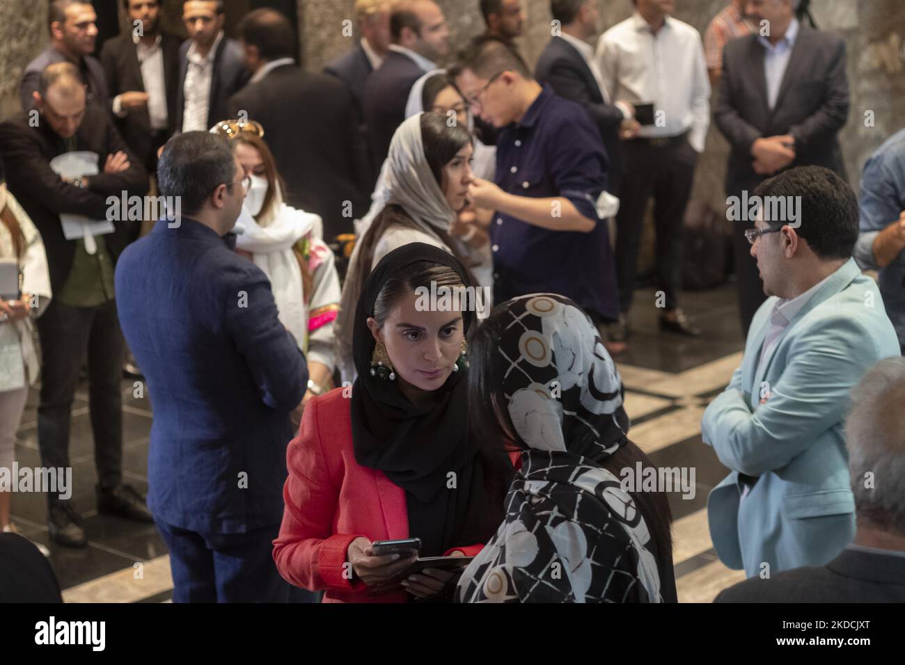 Due donne iraniane parlano tra loro in attesa di registrarsi per l'asta durante l'asta del 7th Art of the Islamic and Iranian Worlds Auction, tenuta dalla Melli (National) Auction House in un centro conferenze nel nord di Teheran il 24 giugno 2022. (Foto di Morteza Nikoubazl/NurPhoto) Foto Stock