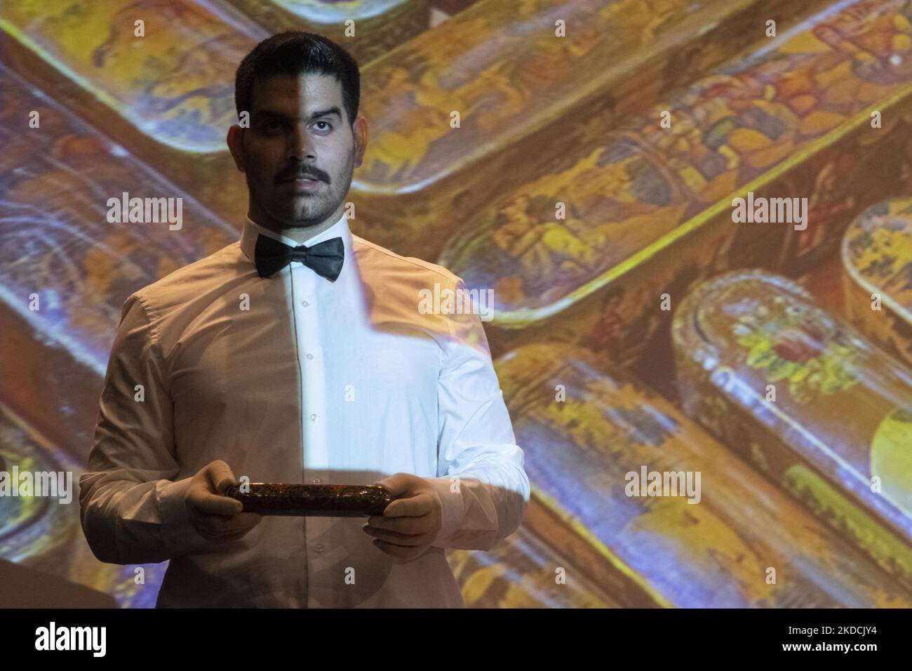 Un uomo tiene in mano una storica lacca a penna che è in vendita all'asta durante l'asta del 7th Art of the Islamic and Iranian Worlds Auction, tenuta dalla Melli (National) Auction House in un centro conferenze nel nord di Teheran il 24 giugno 2022. (Foto di Morteza Nikoubazl/NurPhoto) Foto Stock