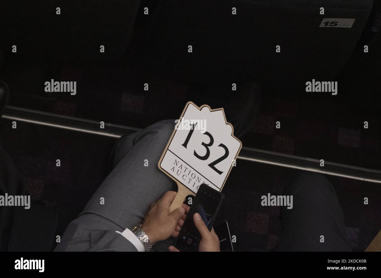 Un uomo iraniano tiene un'asta mentre siede in una sala d'asta durante l'asta del mondo islamico e iraniano del 7th, tenuta dalla casa d'asta di Melli (nazionale) in un centro conferenze nel nord di Teheran il 24 giugno 2022. (Foto di Morteza Nikoubazl/NurPhoto) Foto Stock