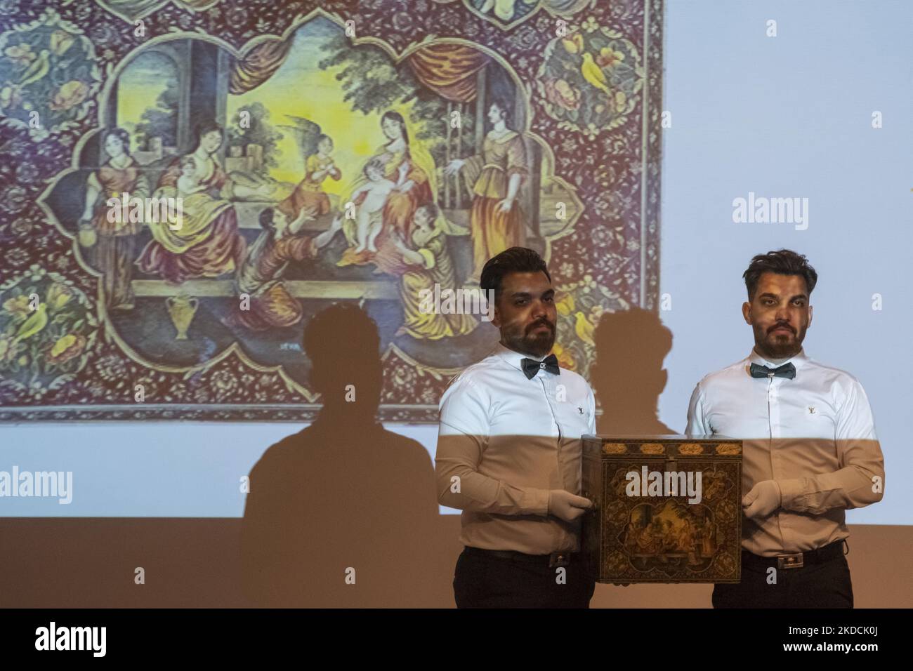 All'asta Islamica e Iraniana del 7th, tenuta dalla Casa d'aste Melli (Nazionale) al Centro Congressi nel nord di Teheran, due dipendenti hanno esposto una scatola di lacca del 1899 di Haidar Ali in una sala d'aste il 24 giugno 2022. (Foto di Morteza Nikoubazl/NurPhoto) Foto Stock