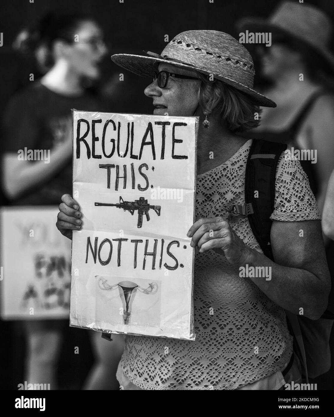 Oltre mille manifestanti si sono riversati in strada venerdì pomeriggio, 24th giugno 2022, fuori dal tribunale federale di Houston, Texas, per esprimere la loro resistenza alla sentenza della Corte suprema rilasciata in precedenza. I texani sono particolarmente vulnerabili dopo il rovesciamento di Roe contro Wade a causa di un progetto di legge del senato di stato in corso che vieterà completamente gli aborti in tutto il Texas. Nella foto: Un dimostratore ha in mano un segno che recita “regolamentare questo non questo” con immagini di un fucile d’assalto e del sistema riproduttivo di una donna. (Foto di Reginald Mathalone/NurPhoto) Foto Stock