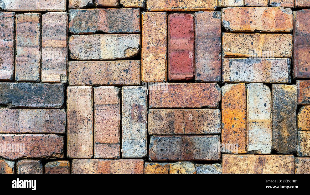 Parete impilata di vecchio sfondo colorato ricattato mattoni Foto Stock