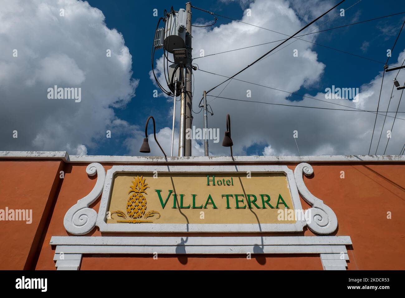 San Salvador, San Salvador, El Salvador - 24 ottobre 2022: Elegante segno bianco e giallo che recita: 'Villa Terra Hotel' su una parete arancione contro Blu Foto Stock