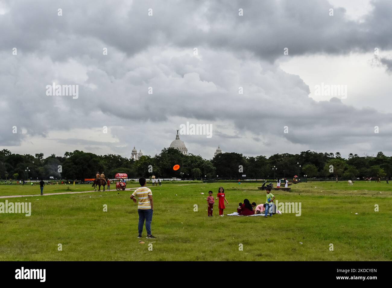 I bambini si vedono giocare in un campo con pesanti nuvole di pioggia sullo sfondo , come si vede a Kolkata , in India , il 29 giugno 2022 . (Foto di Debarchan Chatterjee/NurPhoto) Foto Stock