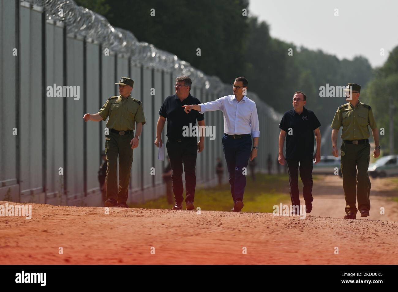 Il primo ministro Mateusz Morawiecki (al centro) è apparso al confine polacco-bielorusso al muro di confine, che il governo polacco ha definito una "barriera fisica". Ha partecipato alla consegna di questa struttura in acciaio e cemento alla Guardia di frontiera, da parte del contraente del progetto, società Budimex, Unibep e Budrex. Il muro di confine al confine polacco-bielorusso è stato costruito con l'uso di 50.000 tonnellate di acciaio. E 'alto 5,5 metri, sormontato da un filo rasoio e si estende per 186,25 km. Il Giovedi, 30 giugno 2022, a Nowodziel, nei pressi di Kuznica, Podlaskie Voivodato, Polonia. (Foto di Artu Foto Stock