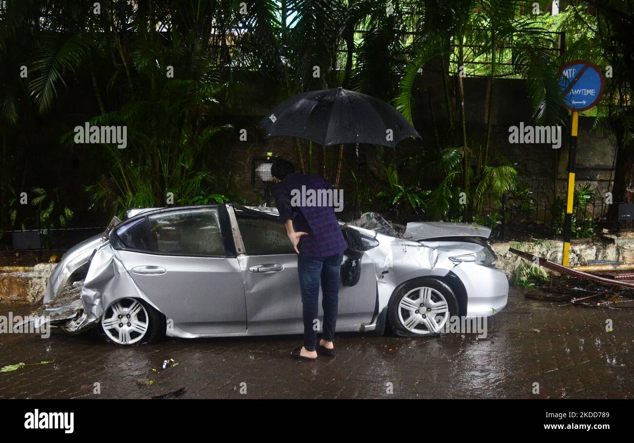 Un uomo si infiltra nell'auto danneggiata dopo un crollo del muro durante le forti precipitazioni a Mumbai, India, 05 luglio 2022. (Foto di Indranil Aditya/NurPhoto) Foto Stock