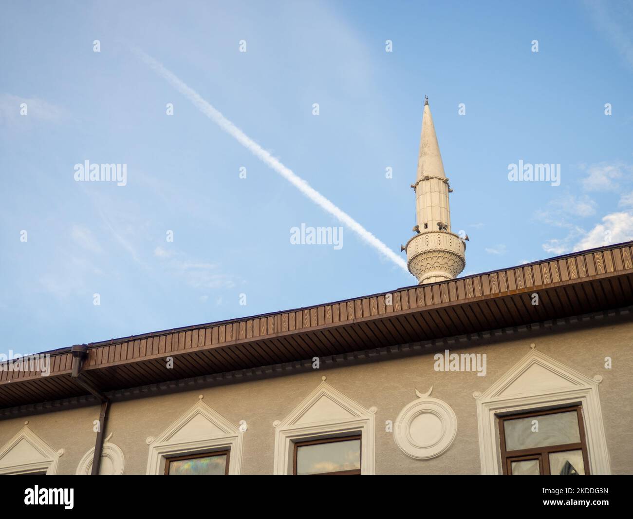 Il minareto della moschea sorge sopra gli edifici. Moschea ad angolo acuto. Islam. Edificio religioso. Foto Stock