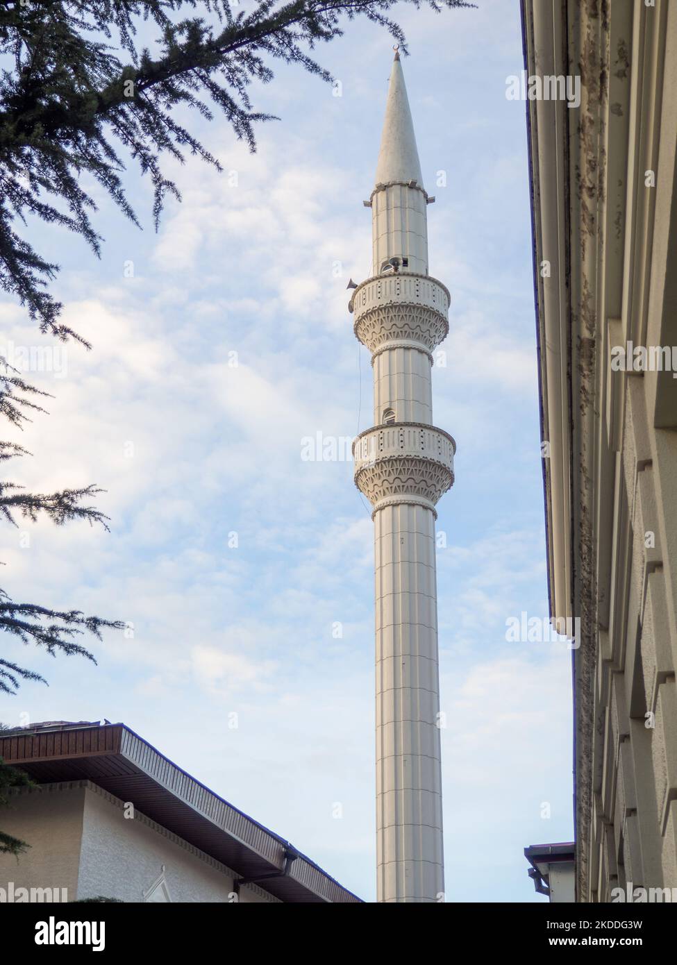 Il minareto della moschea sorge sopra gli edifici. Moschea ad angolo acuto. Islam. Edificio religioso. Foto Stock