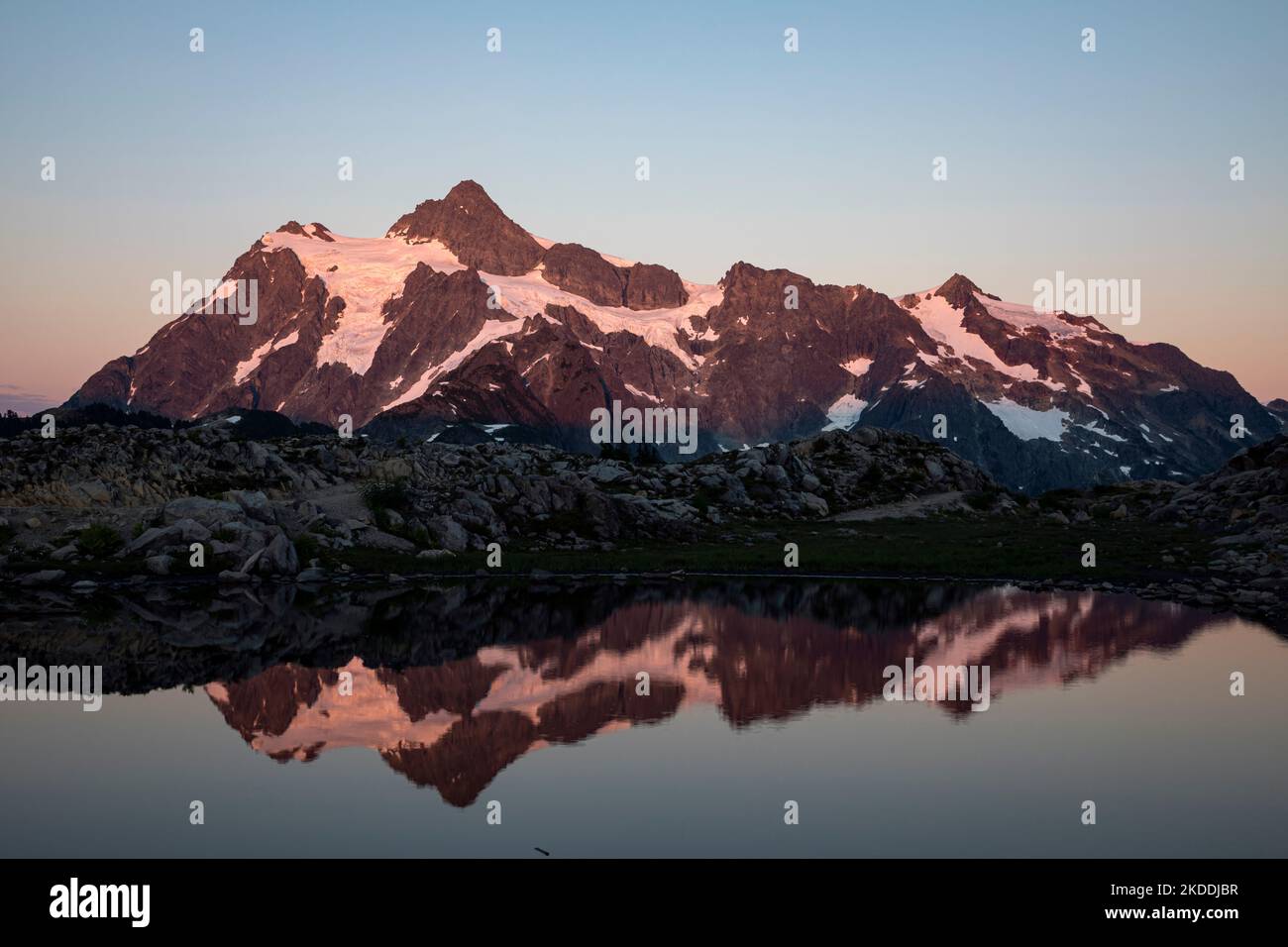 WA22700-00...WASHINGTON - i colori caldi del tramonto sul Monte Shuksan si riflettono in un piccolo tarn a Huntoon Point sul crinale di Kulshan, parte dell'Heather Foto Stock