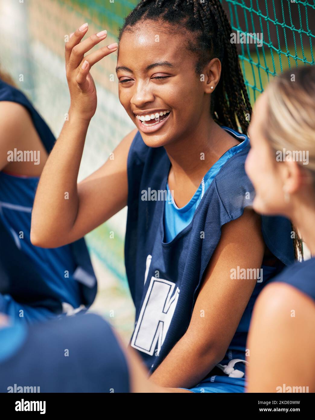 Donna, ridendo o legandosi sul campo sportivo con gli amici della comunità del netball o la gente nell'esercitazione della squadra di sviluppo di diversità. Sorriso felice, persona nera o. Foto Stock