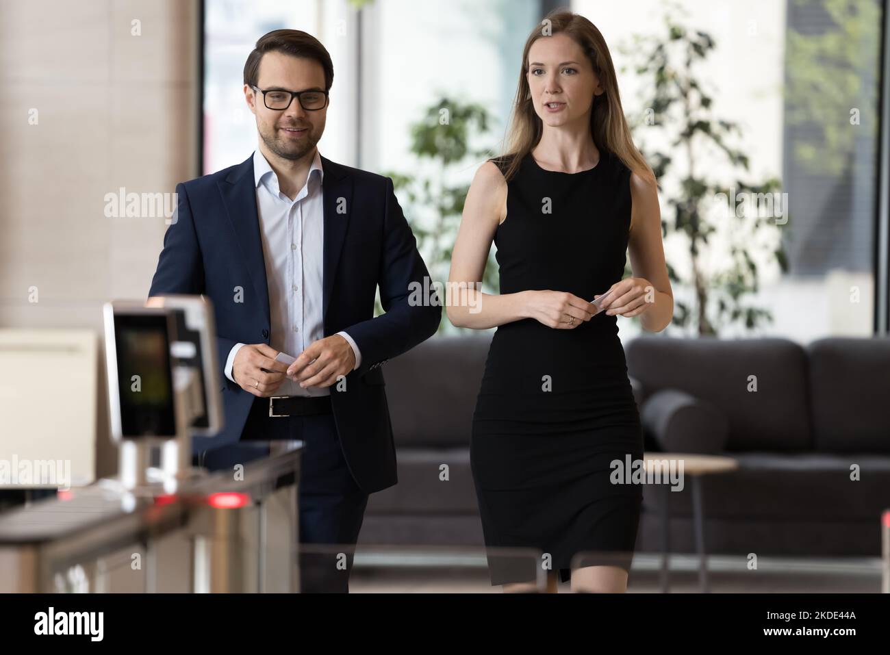 Gli uomini d'affari si avvicinano all'ingresso dell'ufficio con la carta di accesso in mano Foto Stock