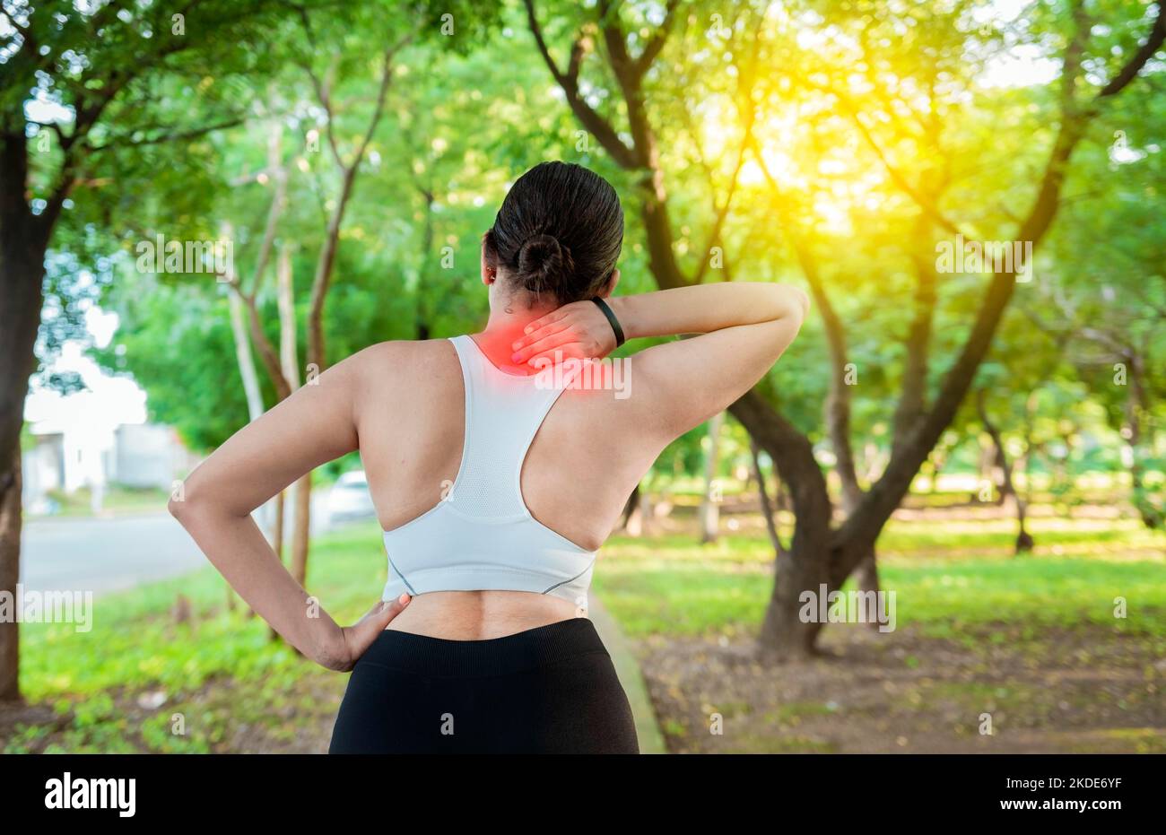 Donna che corre con dolore muscolare alle spalle in un parco. Concetto di dolore alle spalle di un atleta runner. Atleta ragazza in dolore strofinare la spalla all'aperto. Foto Stock