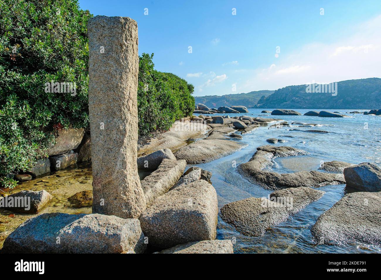 Colonna verticale in granito di epoca romana per l'ormeggio di storiche galee romane navi da carico nell'antico porto romano della penisola di Capo testa Foto Stock