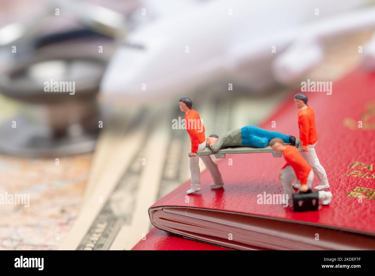 Figure in miniatura del personale paramedico che assiste il malato in un concetto di paese straniero. Foto Stock