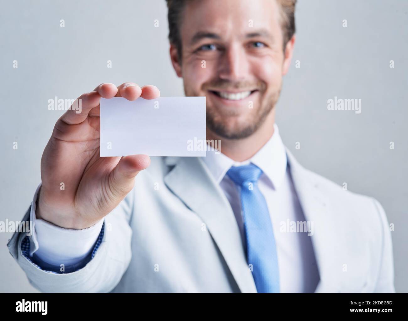 Il successo è solo una telefonata. Studio shot di un uomo d'affari che tiene un biglietto da visita vuoto su uno sfondo grigio. Foto Stock